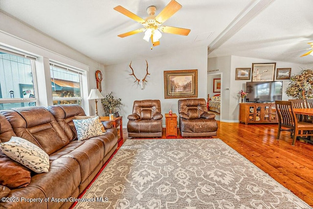 living room with wood-type flooring, ceiling fan, and vaulted ceiling