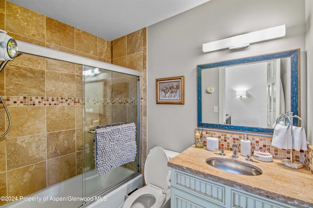 full bathroom with vanity, toilet, shower / bath combination with glass door, and backsplash