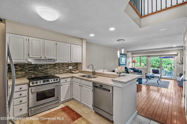 115 Harleston Grn Unit 63, Snowmass Village, CO 81615 - kitchen with stainless steel appliances, under cabinet range hood, a peninsula, open floor plan, and light countertops