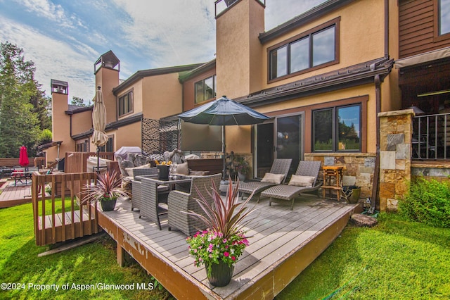 115 Harleston Grn Unit 63, Snowmass Village, CO 81615 - rear view of house featuring stucco siding, a deck, stone siding, and outdoor lounge area