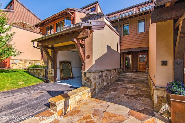 115 Harleston Grn Unit 63, Snowmass Village, CO 81615 - view of front of house featuring stone siding, stucco siding, and entry steps