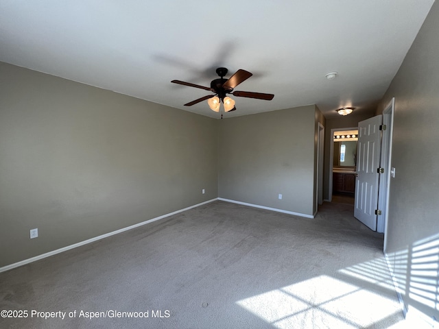 carpeted spare room featuring ceiling fan