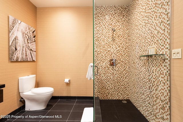 bathroom with tile patterned flooring, a tile shower, and toilet