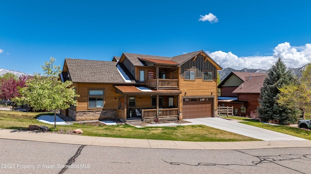 view of front of house featuring a balcony, concrete driveway, an attached garage, stone siding, and a porch