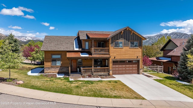 rustic home featuring a balcony, covered porch, concrete driveway, and a mountain view