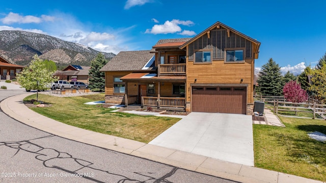 rustic home featuring a balcony, stone siding, a porch, board and batten siding, and driveway