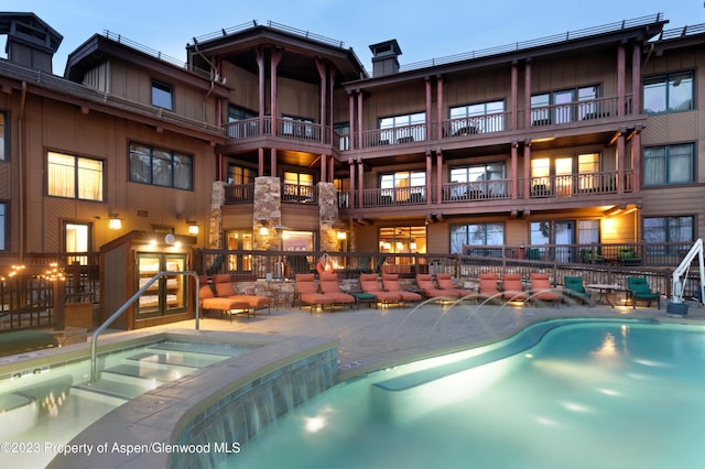 view of swimming pool featuring an in ground hot tub, pool water feature, and a patio area