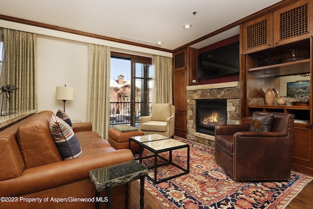 living room featuring hardwood / wood-style flooring, ornamental molding, and a fireplace