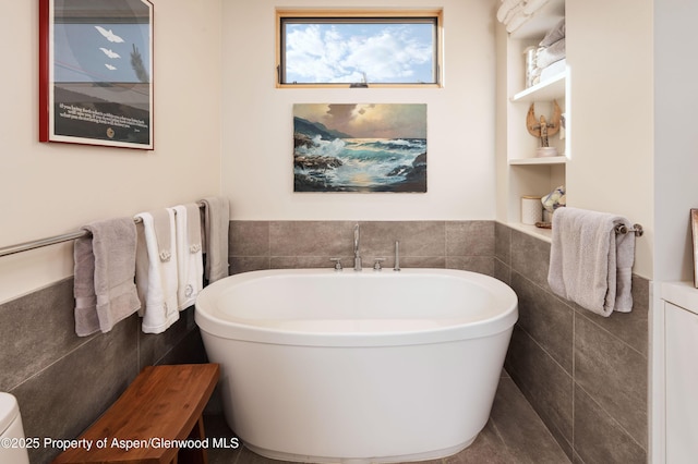 102 Evans Rd Unit 104, Basalt, CO 81621 - bathroom featuring tile walls, a freestanding bath, and a wainscoted wall