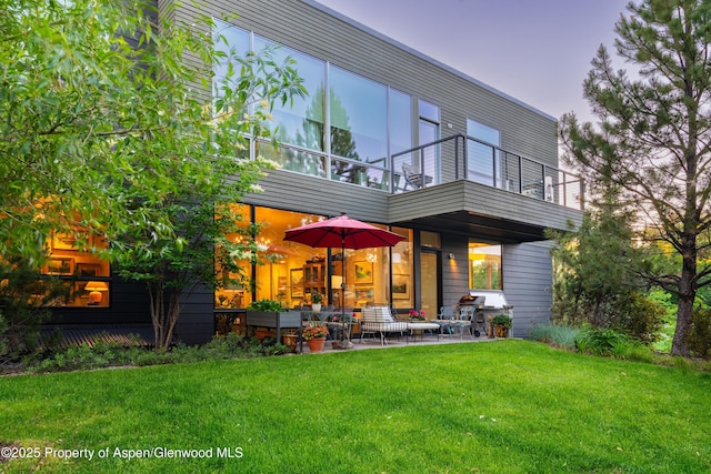 102 Evans Rd Unit 104, Basalt, CO 81621 - back of property at dusk featuring a balcony, a lawn, and a patio