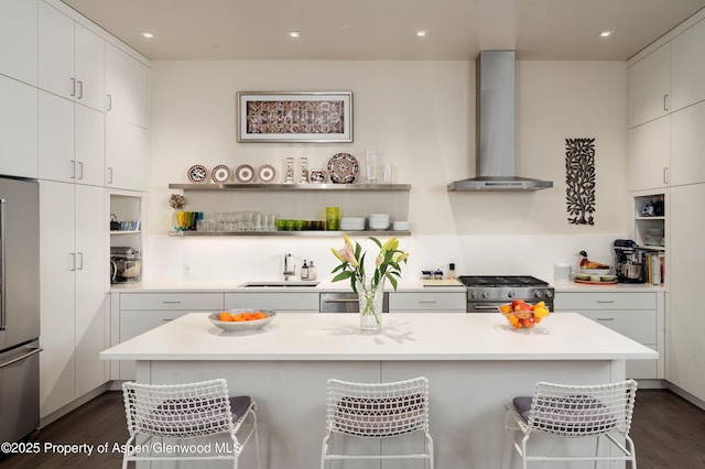 102 Evans Rd Unit 104, Basalt, CO 81621 - kitchen with wall chimney exhaust hood, high end appliances, open shelves, a kitchen breakfast bar, and dark wood-style floors