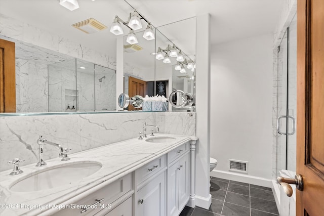 bathroom with backsplash, vanity, a shower with door, tile patterned flooring, and toilet