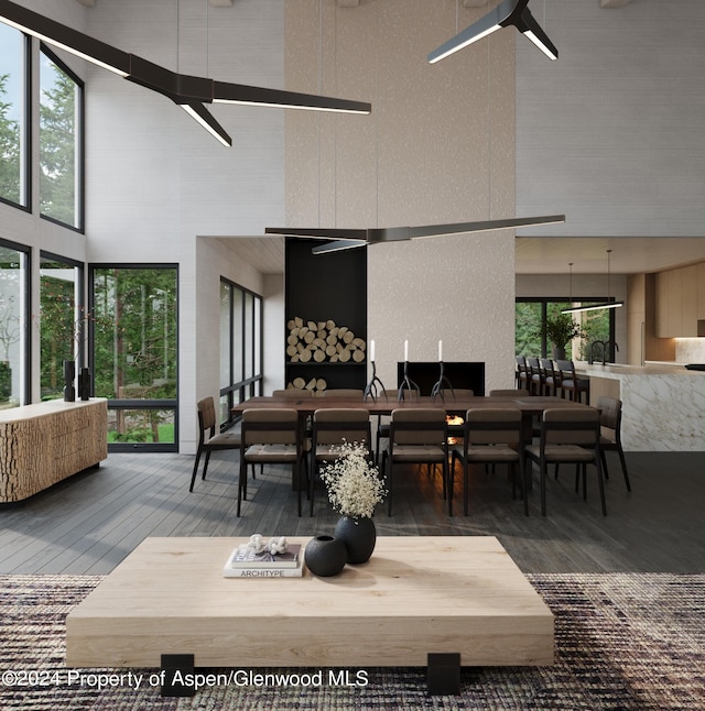 dining room featuring ceiling fan, a towering ceiling, and wood-type flooring