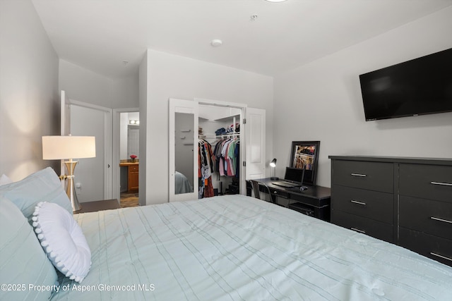 bedroom with a walk in closet, a closet, and ensuite bathroom