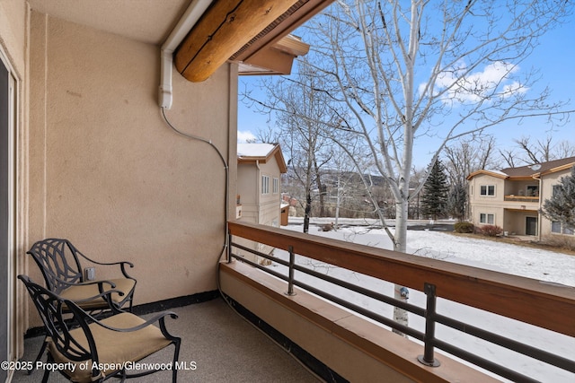 view of snow covered back of property