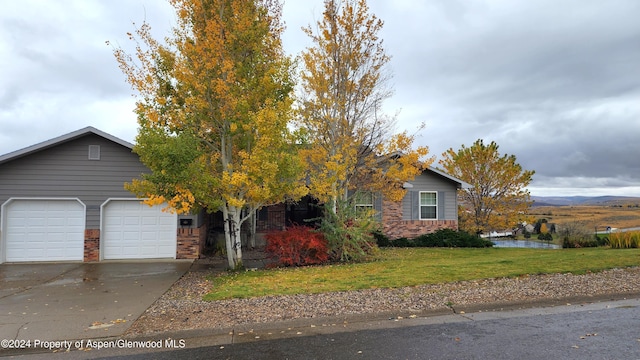 view of property hidden behind natural elements with a front yard and a garage