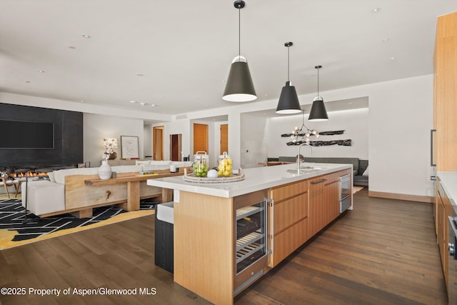 kitchen with dark wood finished floors, light countertops, beverage cooler, and open floor plan