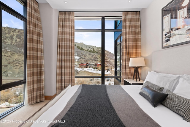 bedroom featuring a mountain view and multiple windows