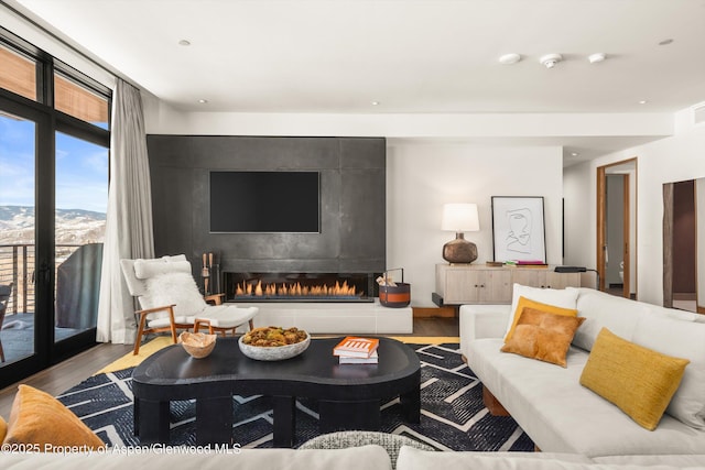 living area featuring a tiled fireplace and wood finished floors