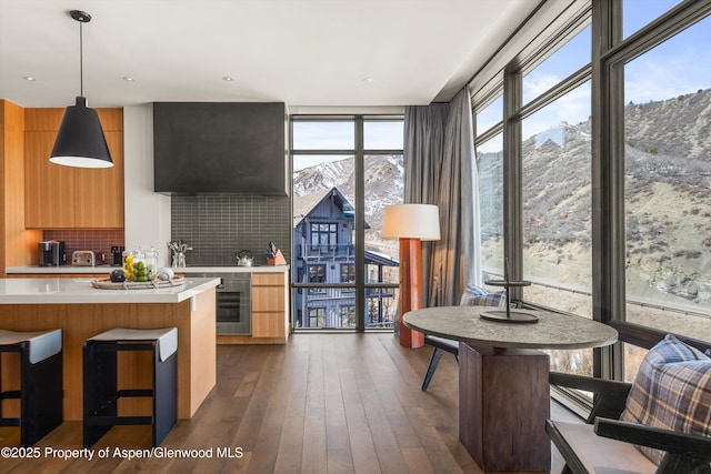 kitchen featuring floor to ceiling windows, modern cabinets, light countertops, and dark wood-style flooring