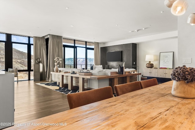 dining room featuring floor to ceiling windows, wood finished floors, and a mountain view