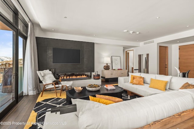 living area featuring hardwood / wood-style floors, recessed lighting, a fireplace, and visible vents