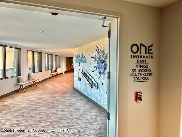 hallway featuring baseboards and wood finished floors