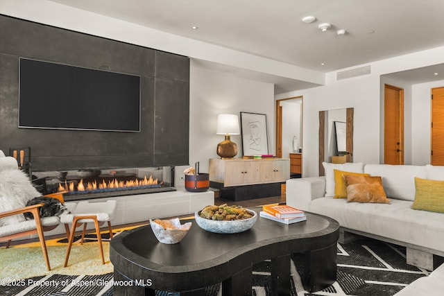 living room with visible vents and a tile fireplace