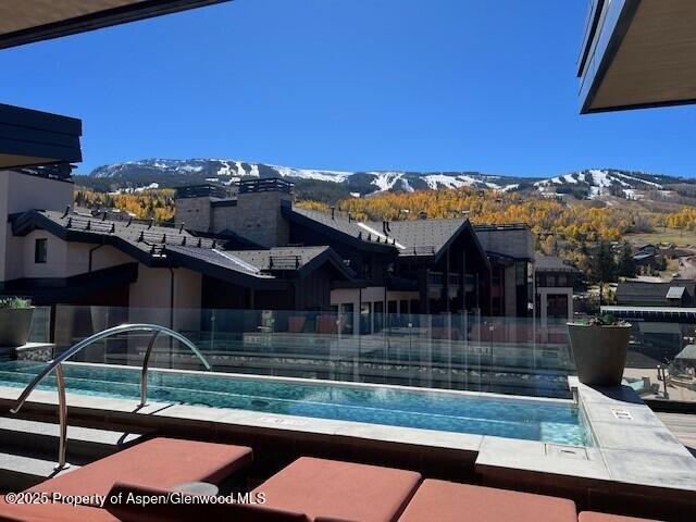 view of pool with a mountain view and fence