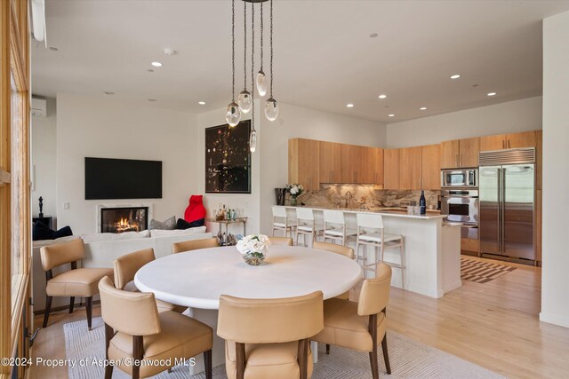 250 Mountain Laurel Dr Unit B, Aspen, CO 81611 - dining room with light wood-type flooring, a lit fireplace, and recessed lighting