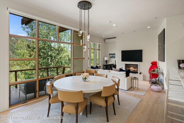 250 Mountain Laurel Dr Unit B, Aspen, CO 81611 - dining space featuring an AC wall unit, a glass covered fireplace, light wood-style flooring, and recessed lighting