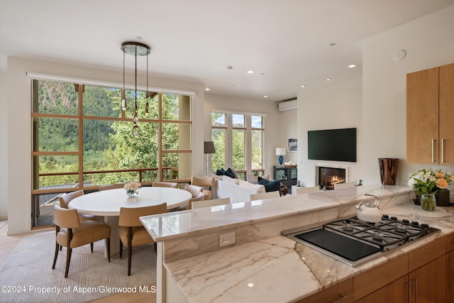 250 Mountain Laurel Dr Unit B, Aspen, CO 81611 - kitchen with a peninsula, gas cooktop, a glass covered fireplace, recessed lighting, and an AC wall unit