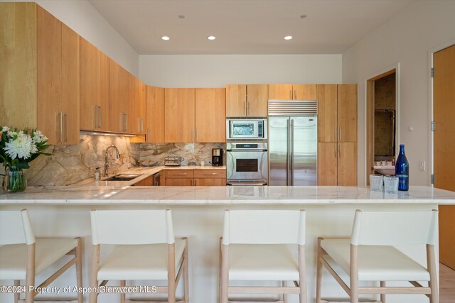250 Mountain Laurel Dr Unit B, Aspen, CO 81611 - kitchen featuring built in appliances, a sink, a peninsula, light countertops, and recessed lighting