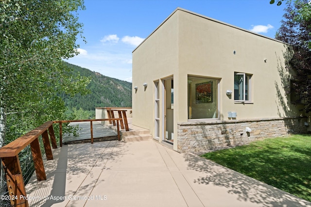 250 Mountain Laurel Dr Unit B, Aspen, CO 81611 - view of home's exterior with stucco siding, a mountain view, and a patio