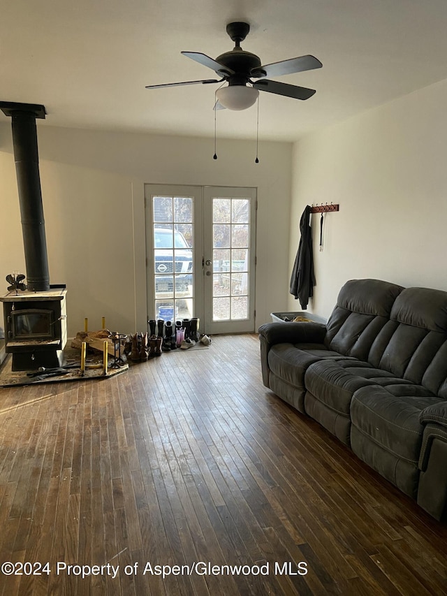 living room featuring a wood stove, ceiling fan, french doors, and hardwood / wood-style flooring