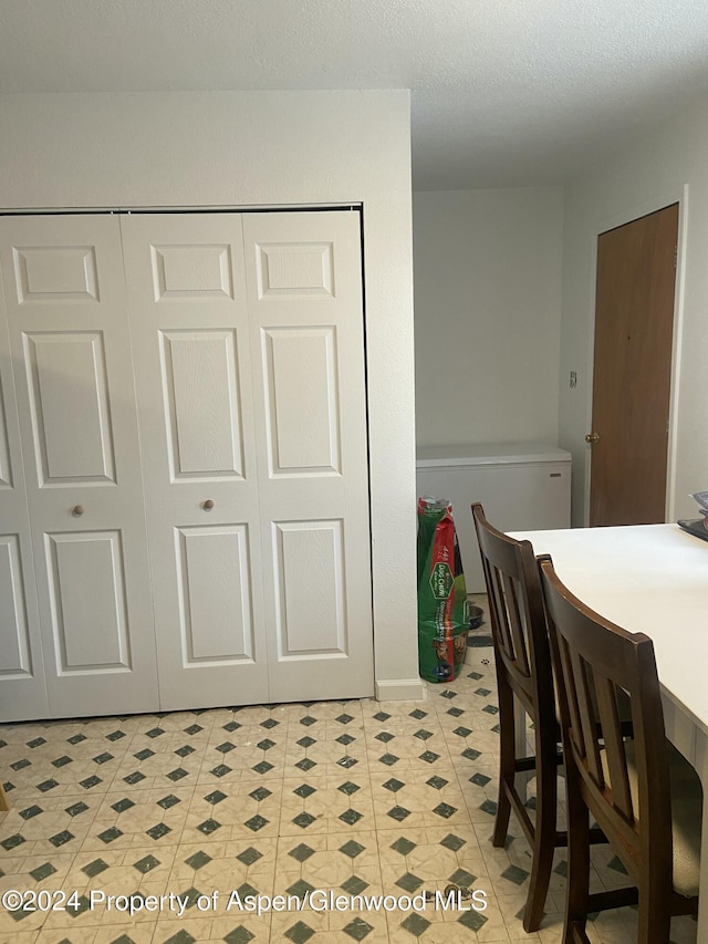 dining room featuring light tile patterned flooring and a textured ceiling