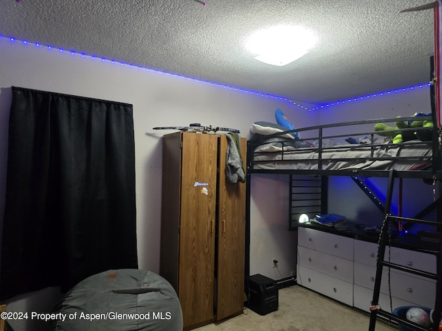 bedroom featuring light carpet and a textured ceiling