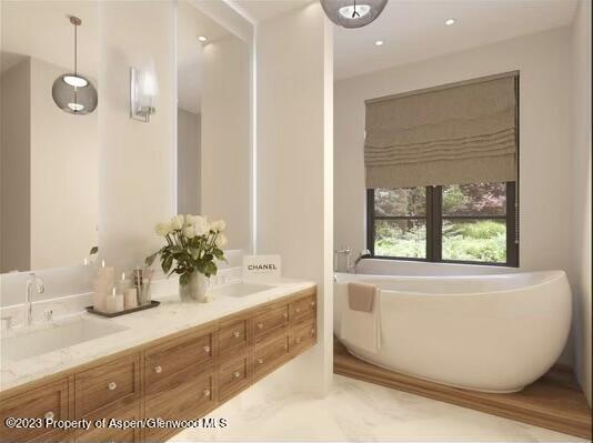 bathroom with a tub and vanity