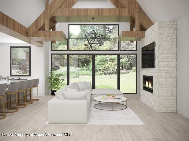 living room featuring a fireplace, light hardwood / wood-style floors, high vaulted ceiling, and beamed ceiling