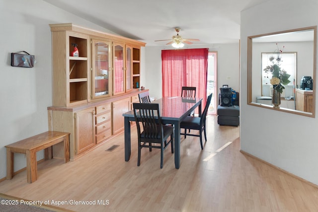 dining space with ceiling fan and light wood-type flooring