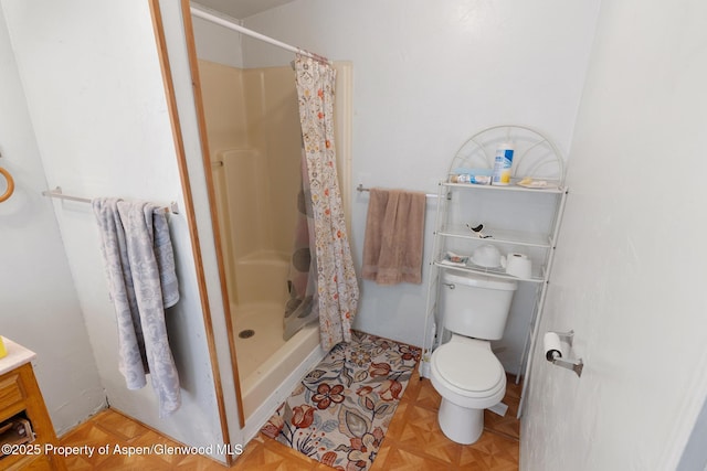 bathroom featuring parquet floors, toilet, and a shower with shower curtain