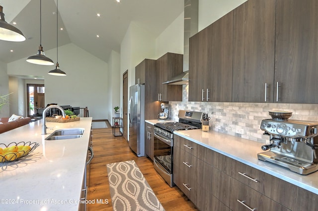 kitchen featuring sink, hanging light fixtures, stainless steel appliances, tasteful backsplash, and high vaulted ceiling