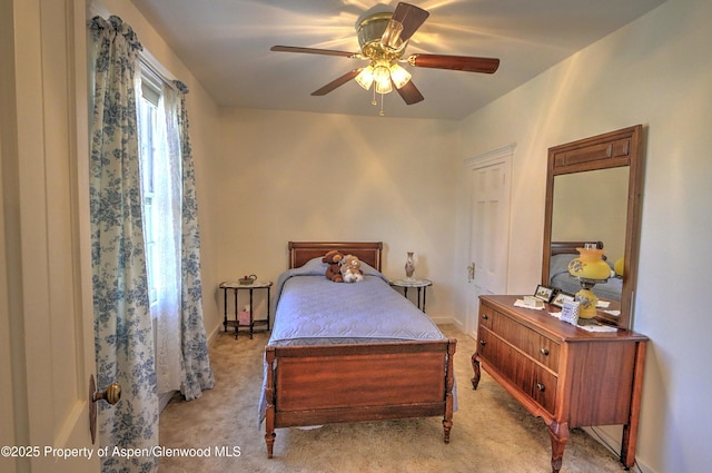bedroom with light colored carpet, baseboards, and a ceiling fan