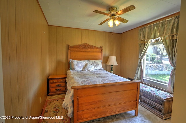 bedroom with wood walls and a ceiling fan