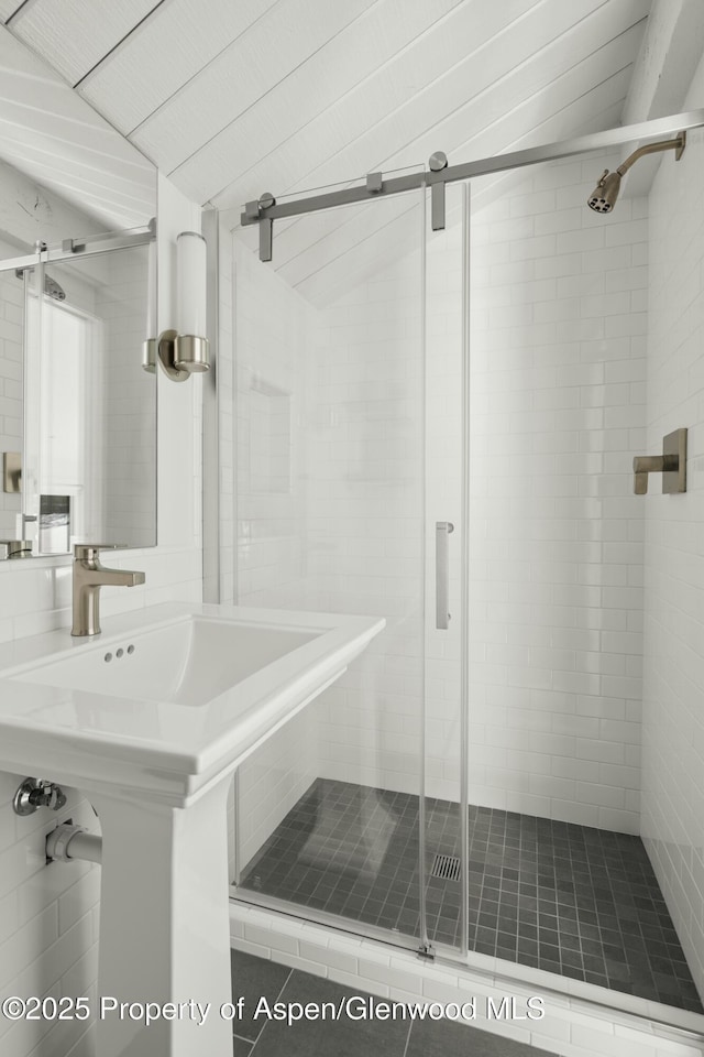 bathroom featuring vaulted ceiling, sink, and a shower with shower door