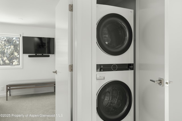 clothes washing area with stacked washer / dryer