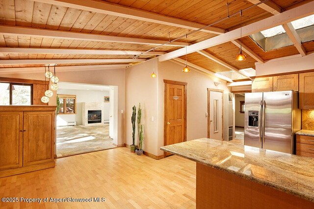 311 Midland Ave, Aspen, CO 81611 - kitchen featuring stainless steel refrigerator with ice dispenser, light wood-type flooring, wooden ceiling, a glass covered fireplace, and a skylight