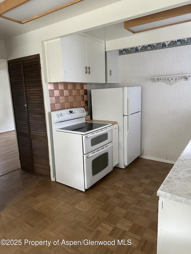 890 Breeze St, Craig, CO 81625 - kitchen with white appliances, light countertops, white cabinetry, and decorative backsplash