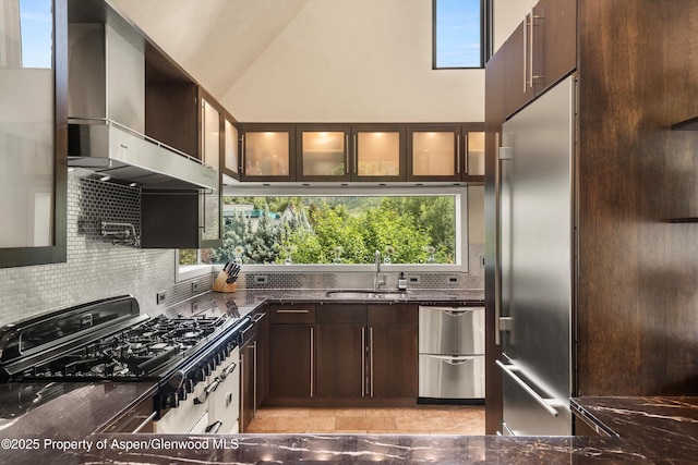 939 E Cooper Ave, Aspen, CO 81611 - kitchen featuring a towering ceiling, exhaust hood, plenty of natural light, dark brown cabinetry, and tasteful backsplash