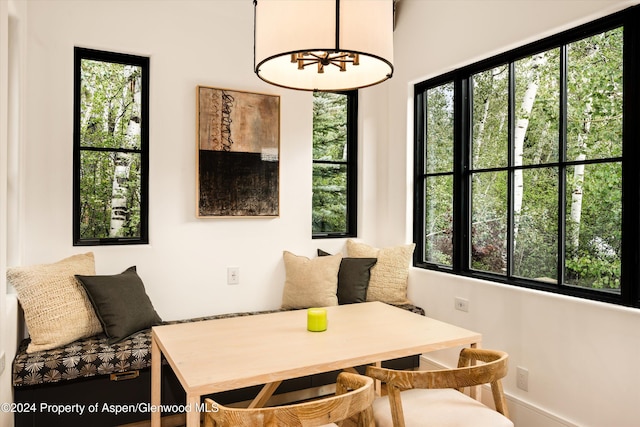 interior space with breakfast area, a wealth of natural light, and a chandelier